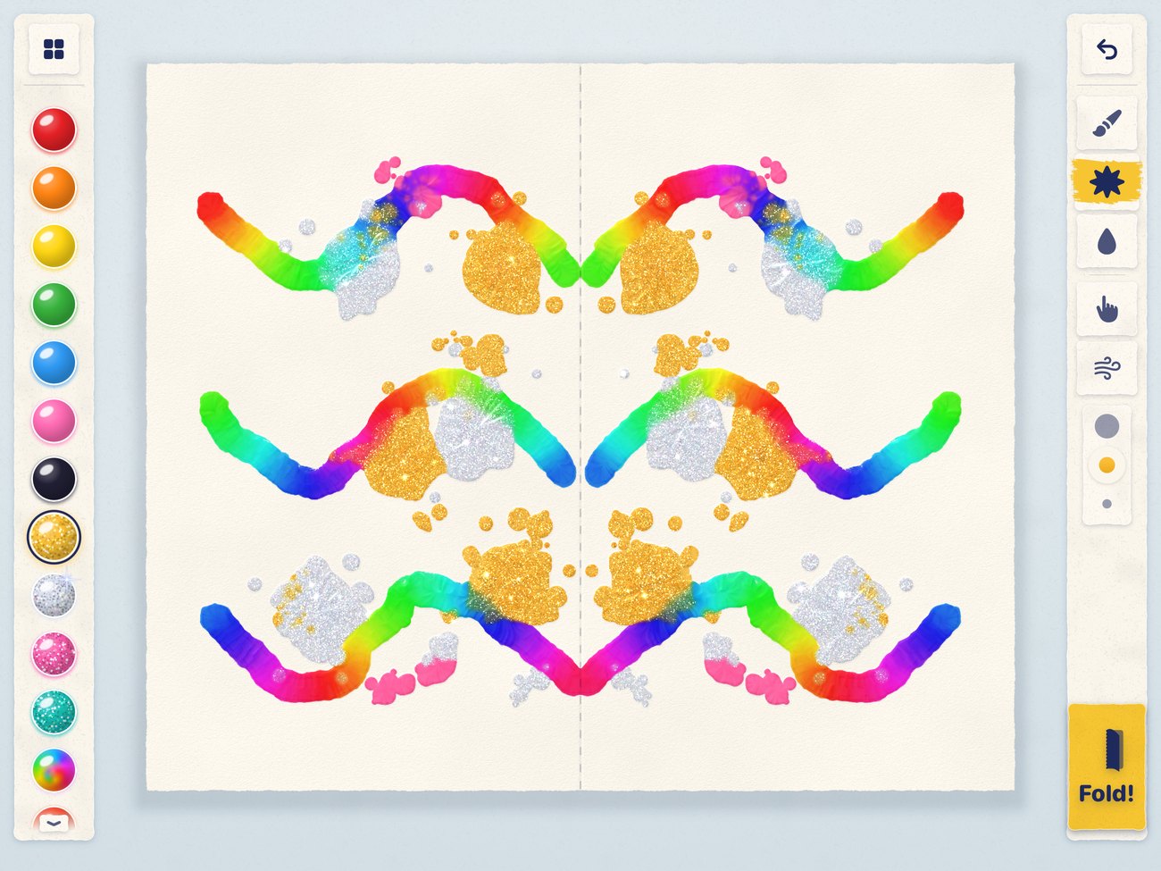 A glittery print with gold and star glitter and rainbow paint.